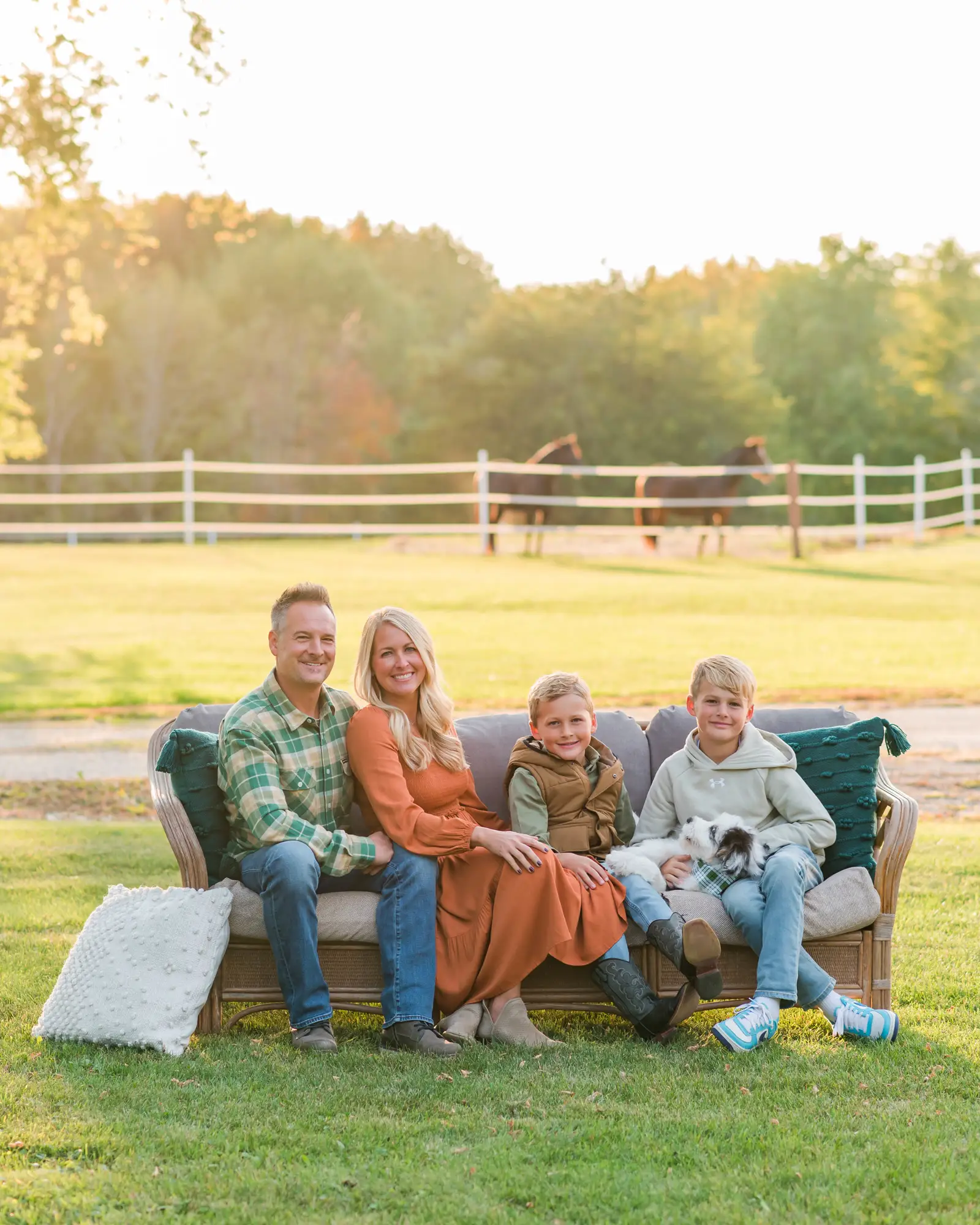 Zack Genrich with his wife and two sons, outdoors at golden hour — the Genrich family has owned Plymouth Plumbing & Heating since 2021