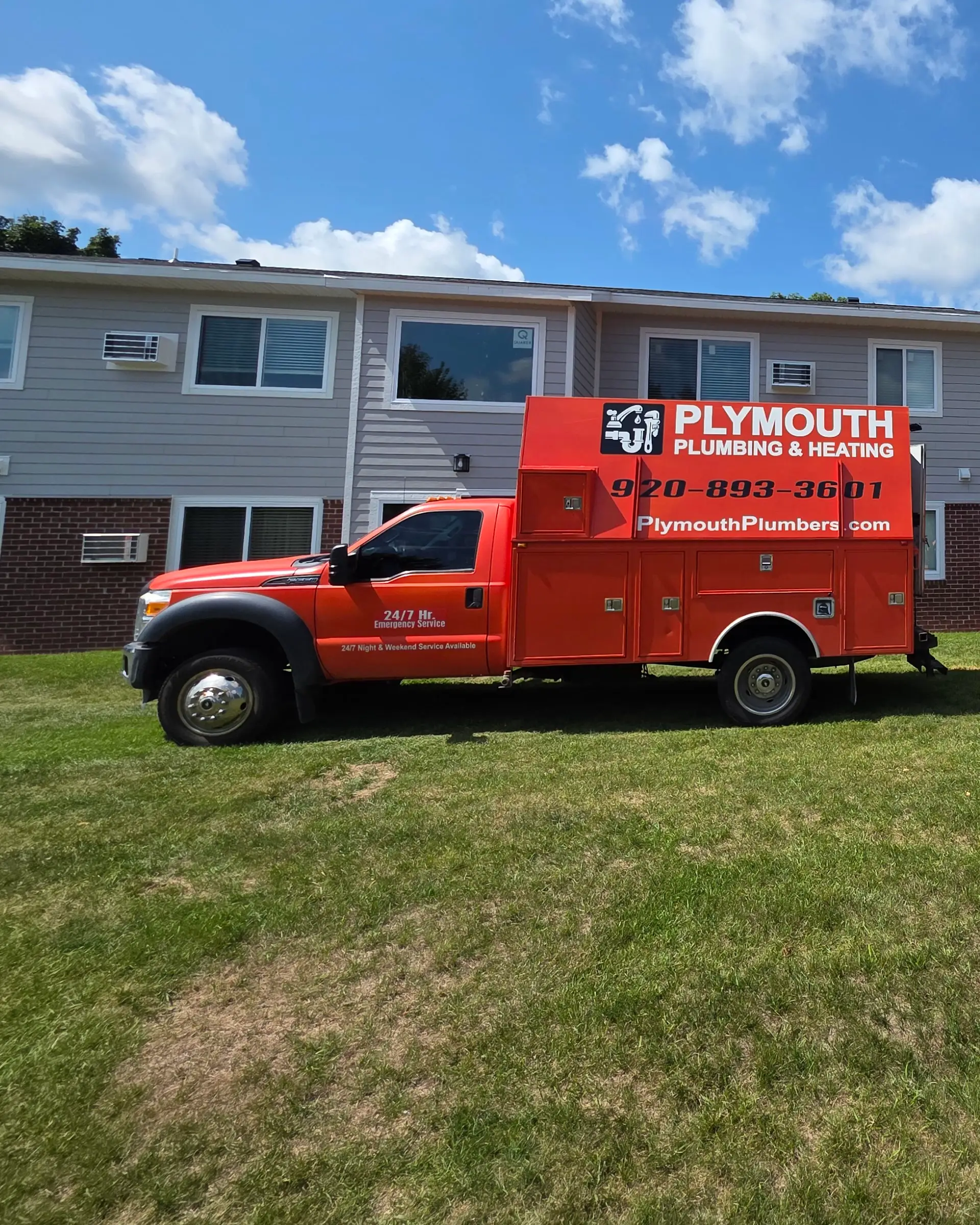 Plymouth Plumbing & Heating service truck on a job site, lettered with (920) 893-3601 and PlymouthPlumbers.com